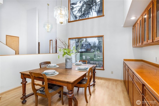 dining room with light wood finished floors, plenty of natural light, and baseboards