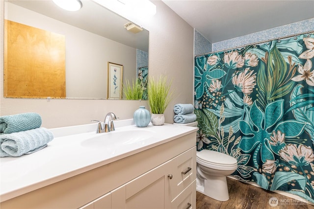 bathroom featuring toilet, wood finished floors, and vanity