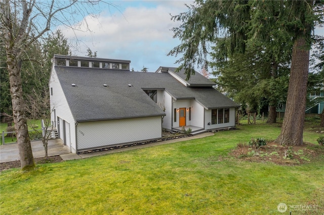 view of front of house with a garage, a front lawn, concrete driveway, and roof with shingles