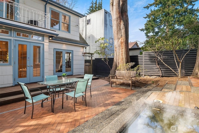 view of patio / terrace with french doors, outdoor dining area, and fence