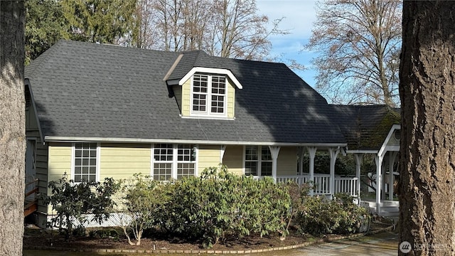 view of front of home featuring a porch and roof with shingles