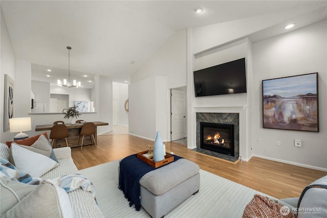 living area with a fireplace, baseboards, and wood finished floors