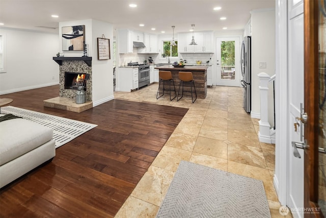 living room with a fireplace, light wood-style flooring, recessed lighting, and baseboards