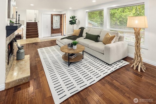 living room featuring recessed lighting, baseboards, wood-type flooring, and stairs