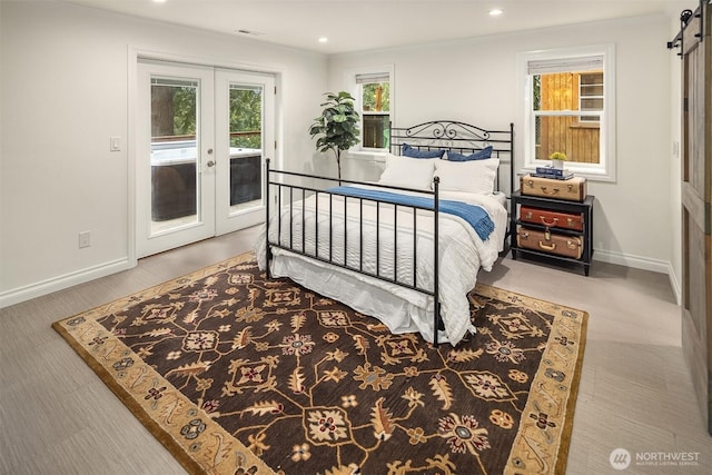 bedroom with baseboards, recessed lighting, french doors, a barn door, and access to outside