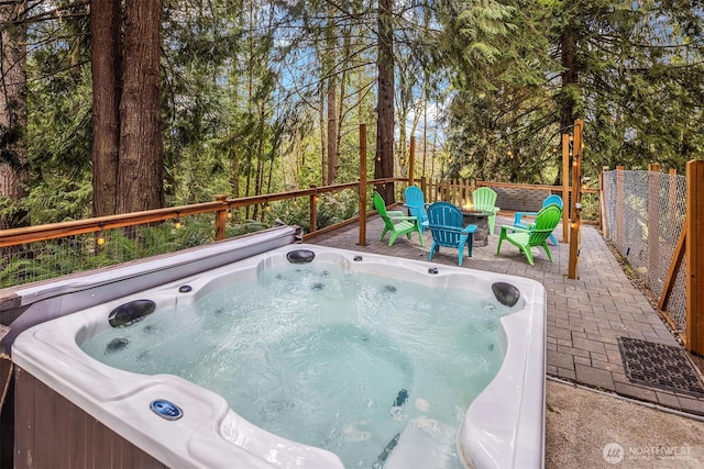 view of pool with a hot tub and fence