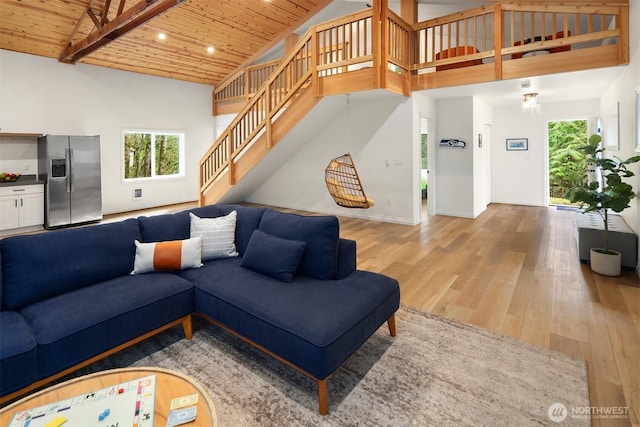 living room featuring stairway, wood finished floors, high vaulted ceiling, and wooden ceiling