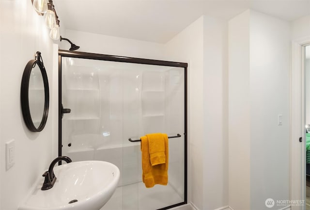 bathroom featuring a stall shower and a sink