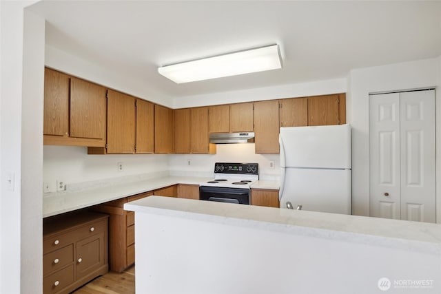 kitchen featuring freestanding refrigerator, under cabinet range hood, light countertops, and electric range