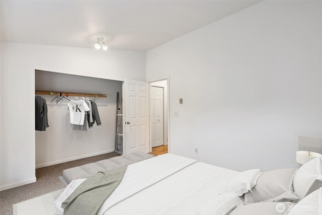 carpeted bedroom featuring baseboards and vaulted ceiling