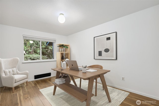 home office featuring wood finished floors and baseboards