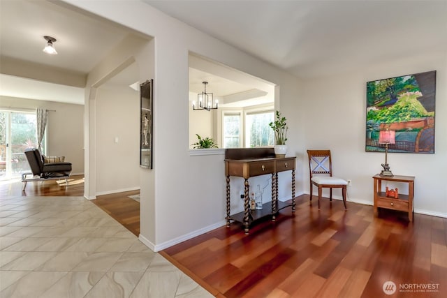 living area with an inviting chandelier, wood finished floors, and baseboards