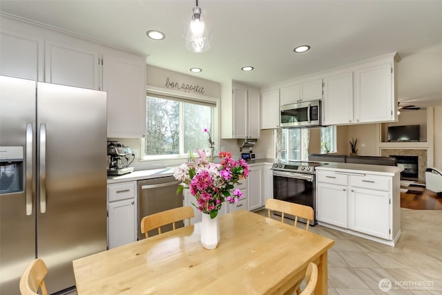 kitchen featuring light tile patterned floors, recessed lighting, appliances with stainless steel finishes, white cabinetry, and a peninsula