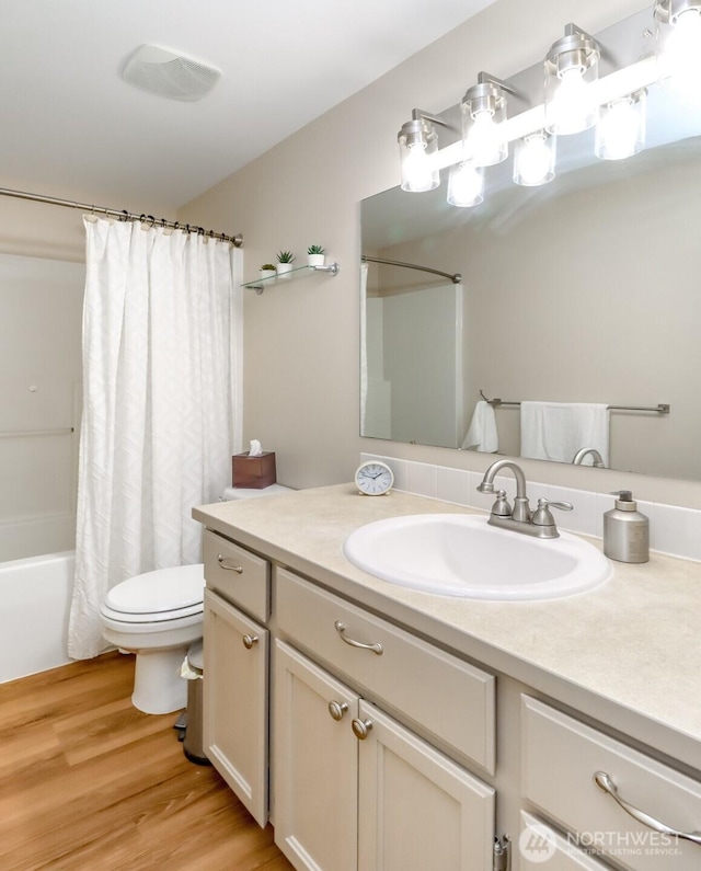 bathroom featuring vanity, shower / bath combo, wood finished floors, and toilet