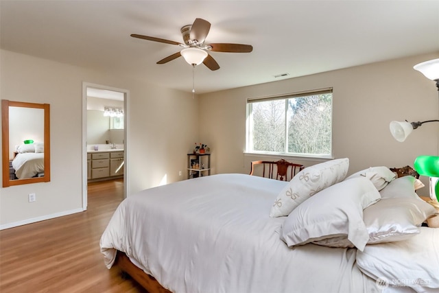 bedroom featuring baseboards, visible vents, a ceiling fan, connected bathroom, and wood finished floors