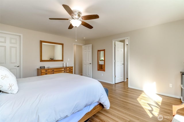 bedroom featuring a ceiling fan, light wood-style flooring, and baseboards