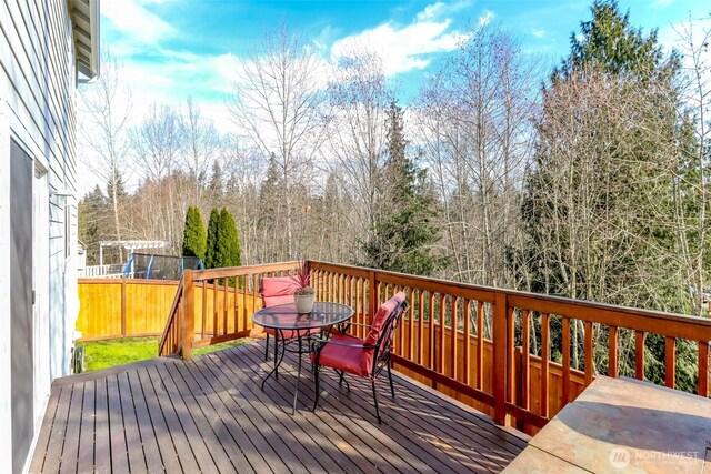 wooden deck with outdoor dining space and fence