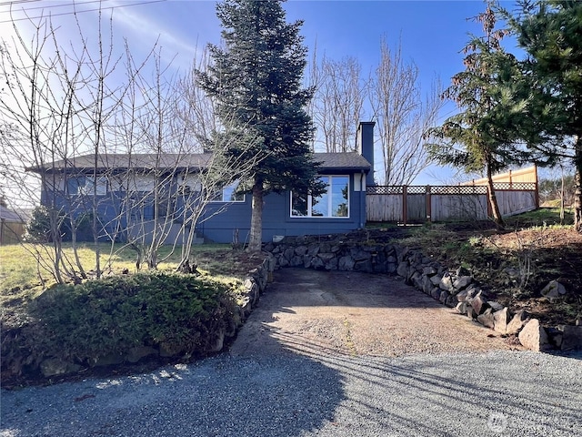 ranch-style house with fence and a chimney