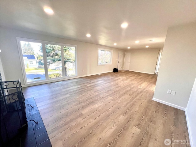 unfurnished living room with recessed lighting, visible vents, baseboards, and wood finished floors