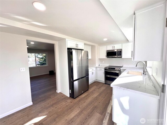 kitchen featuring a sink, baseboards, white cabinets, appliances with stainless steel finishes, and dark wood finished floors