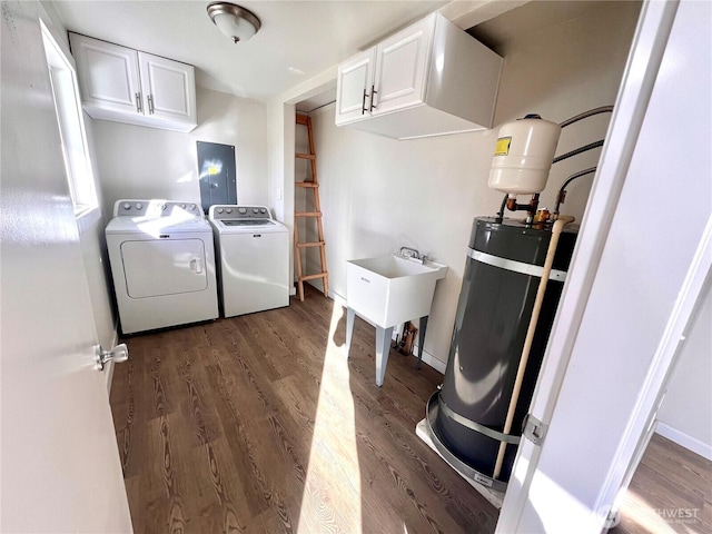 laundry room featuring strapped water heater, cabinet space, wood finished floors, washer and dryer, and electric panel