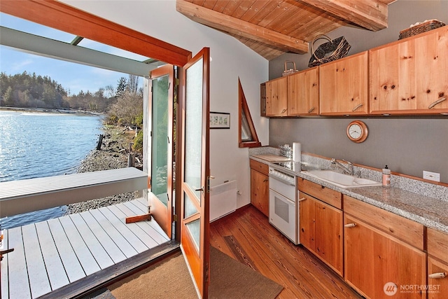 kitchen with vaulted ceiling with beams, light countertops, wood ceiling, a sink, and wood finished floors