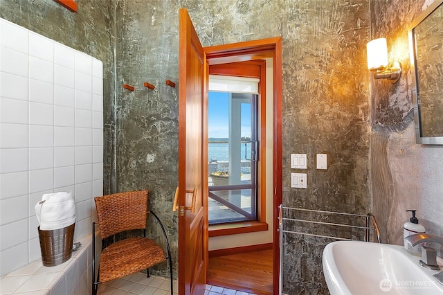 bathroom with a sink and tile walls