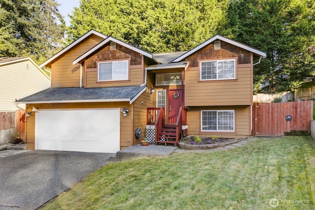 view of front of house featuring a garage, a shingled roof, aphalt driveway, fence, and a front yard