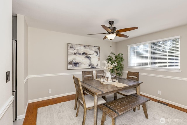 dining area with visible vents, ceiling fan, light wood-style flooring, and baseboards