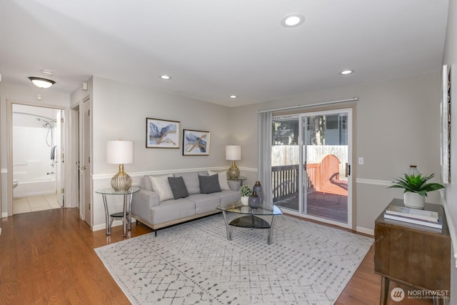 living area with baseboards, wood finished floors, and recessed lighting