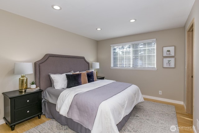 bedroom with baseboards, recessed lighting, and light wood-style floors