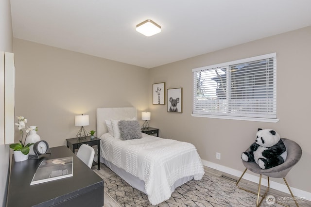 bedroom with light wood-style flooring and baseboards