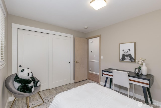 bedroom featuring baseboards, a closet, and wood finished floors