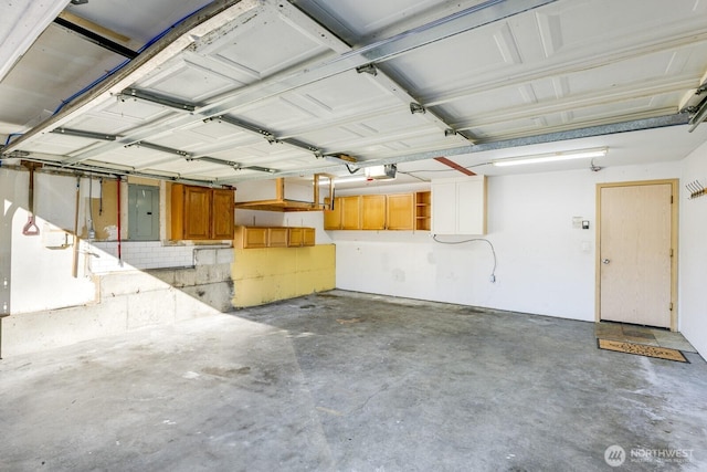 garage with a garage door opener and electric panel