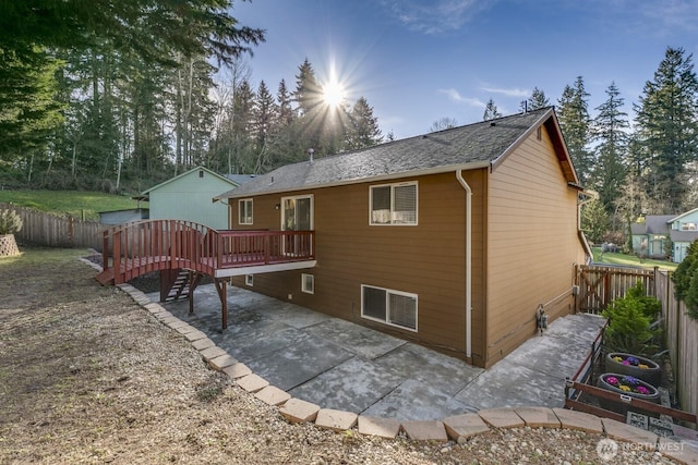 back of property with a wooden deck, a fenced backyard, and a patio