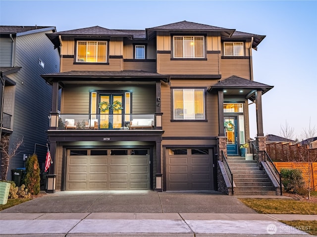 prairie-style home featuring a garage, driveway, board and batten siding, and a balcony