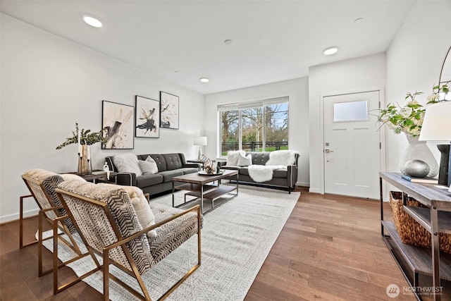 living area with recessed lighting, baseboards, and wood finished floors