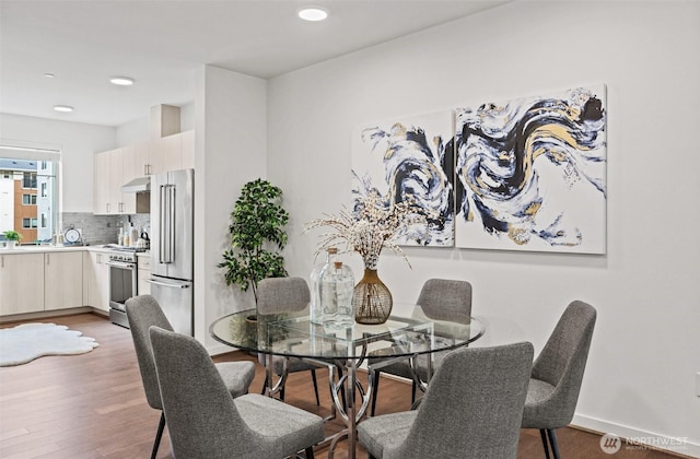 dining space with recessed lighting, baseboards, and light wood-type flooring