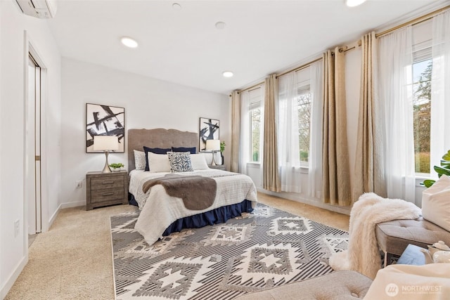 bedroom with light carpet, recessed lighting, a wall mounted air conditioner, and baseboards