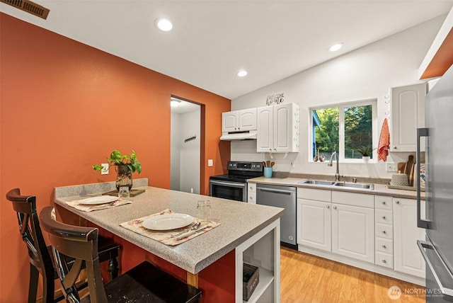 kitchen with stainless steel appliances, a breakfast bar, a sink, visible vents, and light wood-type flooring