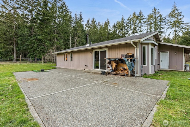 rear view of house with a patio area, fence, and a yard