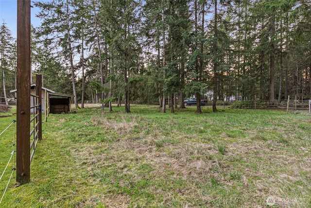 view of yard featuring fence and an outbuilding