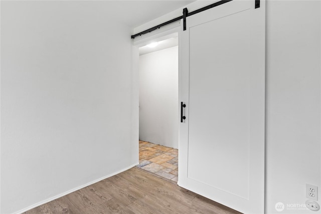 interior space featuring wood finished floors and a barn door