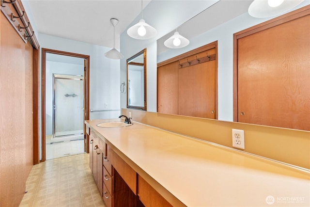 bathroom with a stall shower, vanity, and tile patterned floors