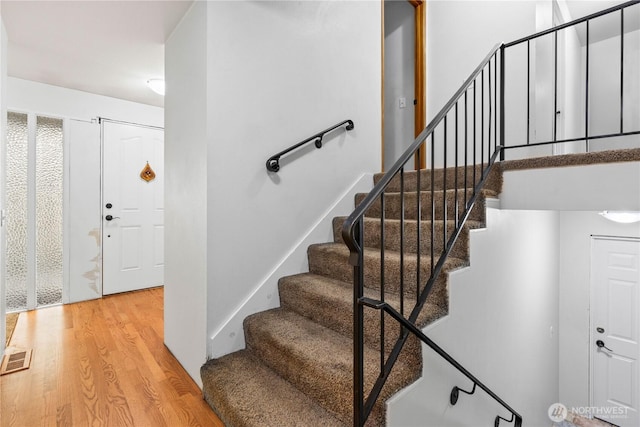 stairway with visible vents and wood finished floors