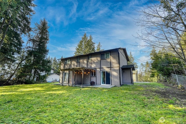 back of property with a lawn, a patio area, and fence