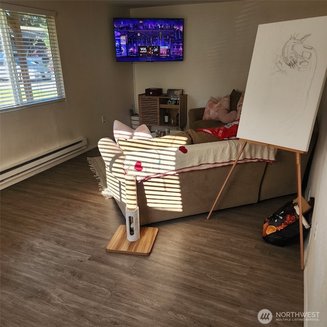 bedroom with a baseboard heating unit and wood finished floors