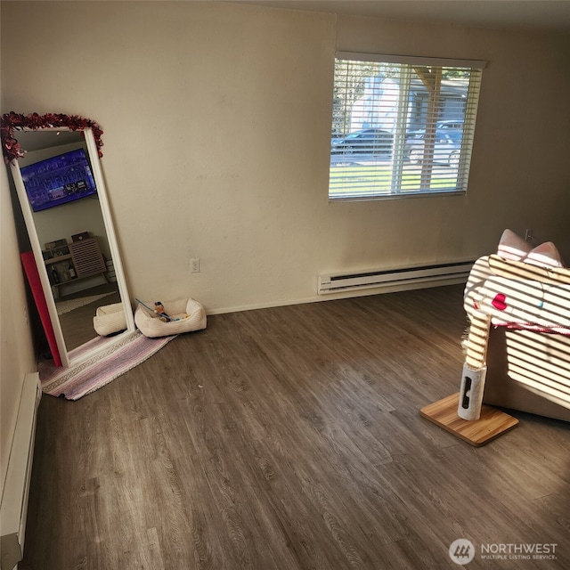 unfurnished bedroom featuring a baseboard radiator, baseboard heating, and wood finished floors