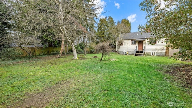 view of yard featuring entry steps and fence