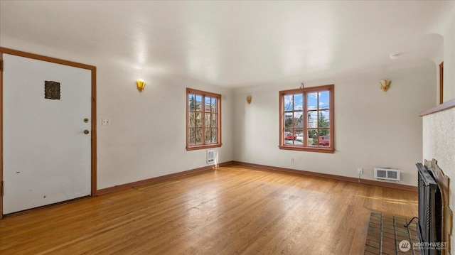 unfurnished living room featuring light wood-type flooring and baseboards